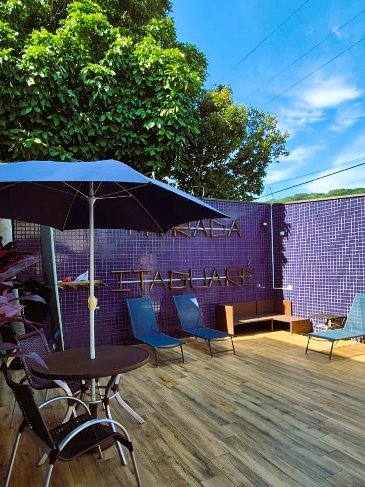 Piscina da hospedagem com deck e espreguiçadeiras.