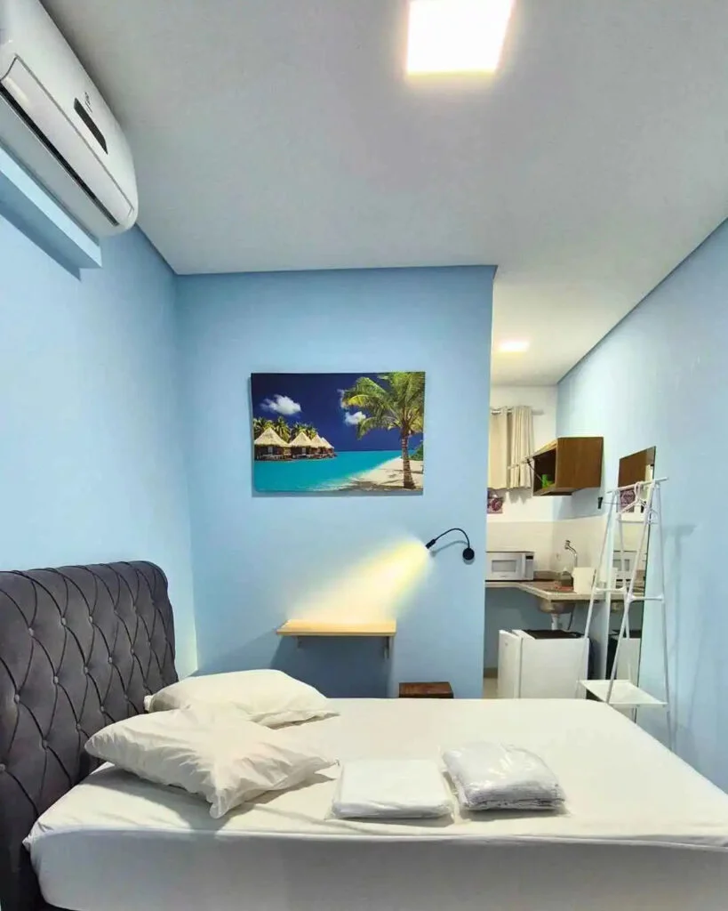 Quarto com cama de casal, bancada e mini copa integrada.