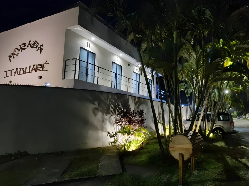 Fachada iluminada da Morada entre palmeiras